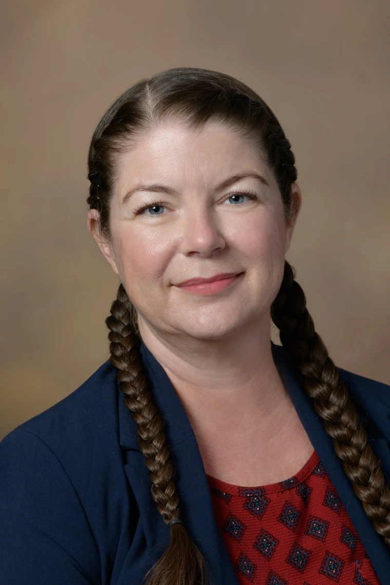 image of woman with brown hair in braids smiling at camera